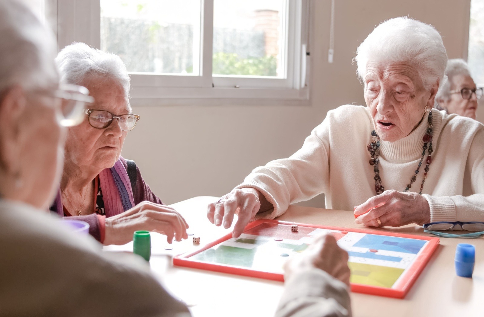 A group of seniors play a board game together.